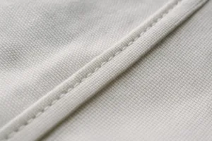 A macro photo accentuating the robustness of plain weave fabric and stitching, visually supporting the section about plain weave characteristics for practical garments.