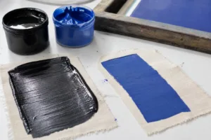 A realistic comparison scene showing how different screen printing inks behave on garment fabrics.