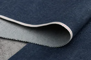 A detailed textile close-up that highlights the finished selvage edge and denim weave structure.